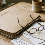 A worn folder of medical papers and reading glasses on a kitchen table